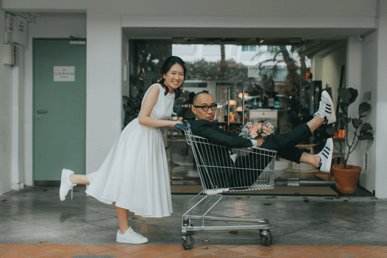 Victoria + CK wedding photography: Couple in shopping cart on Haji Lane, Singapore.
