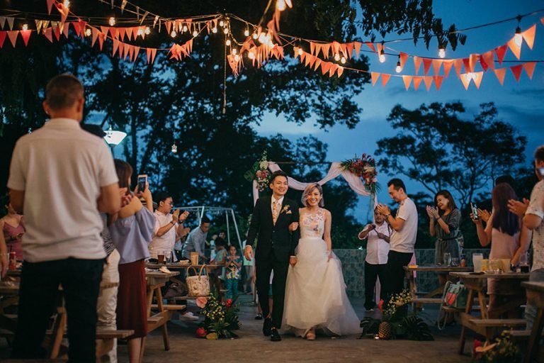 Bride and groom walk through wedding reception at Little Island Brewing Co. Singapore.