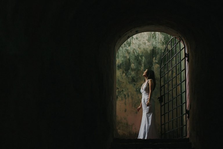 Bride in white dress looking up in an arched doorway in Everton Park, Singapore prewedding.