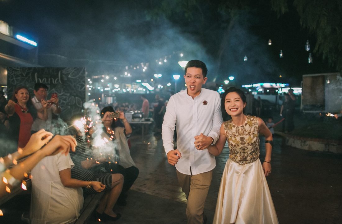Couple running through sparklers at Little Island Brewing Co. wedding, Singapore.
