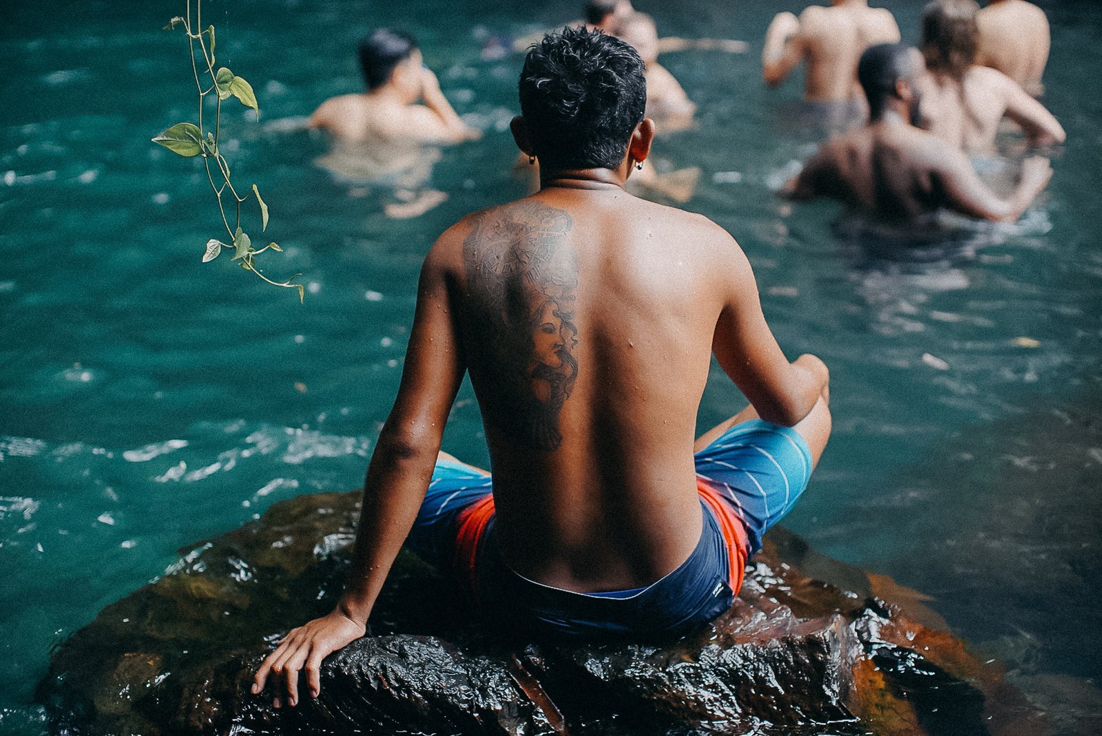 Man with back tattoo meditating in Bali water, Bali destination wedding photography