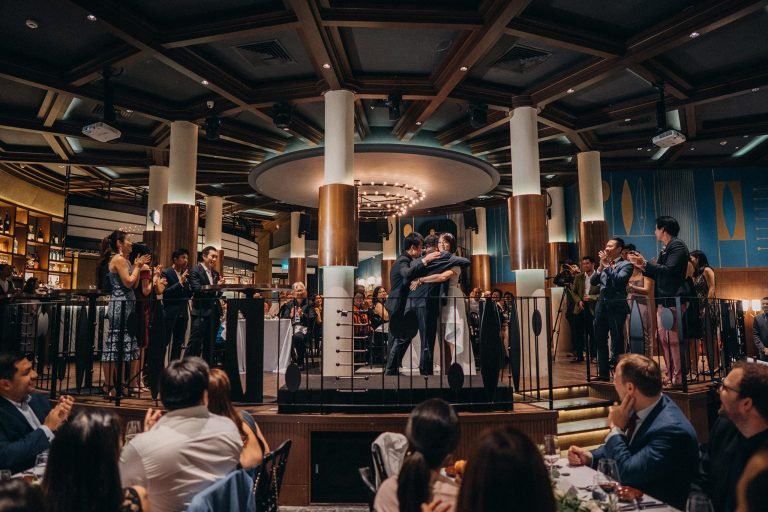 Monti wedding photography: Couple hugs on stage at Singapore reception