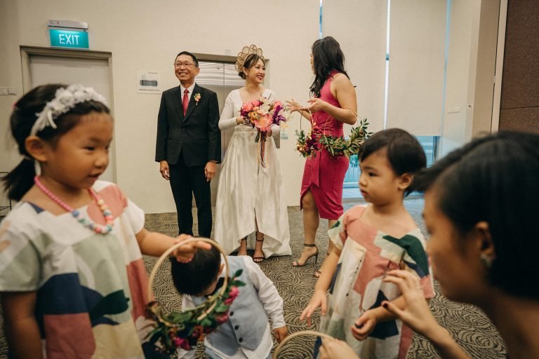 bride standing ready with flower boys and girls in the foreground at holy grace presbyterian church wedding in singapore