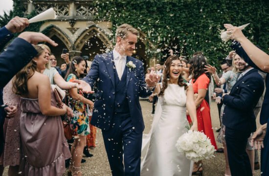 a wedding in cheltenham UK with couple marching out with their friends celebrating by singapore wedding photographer