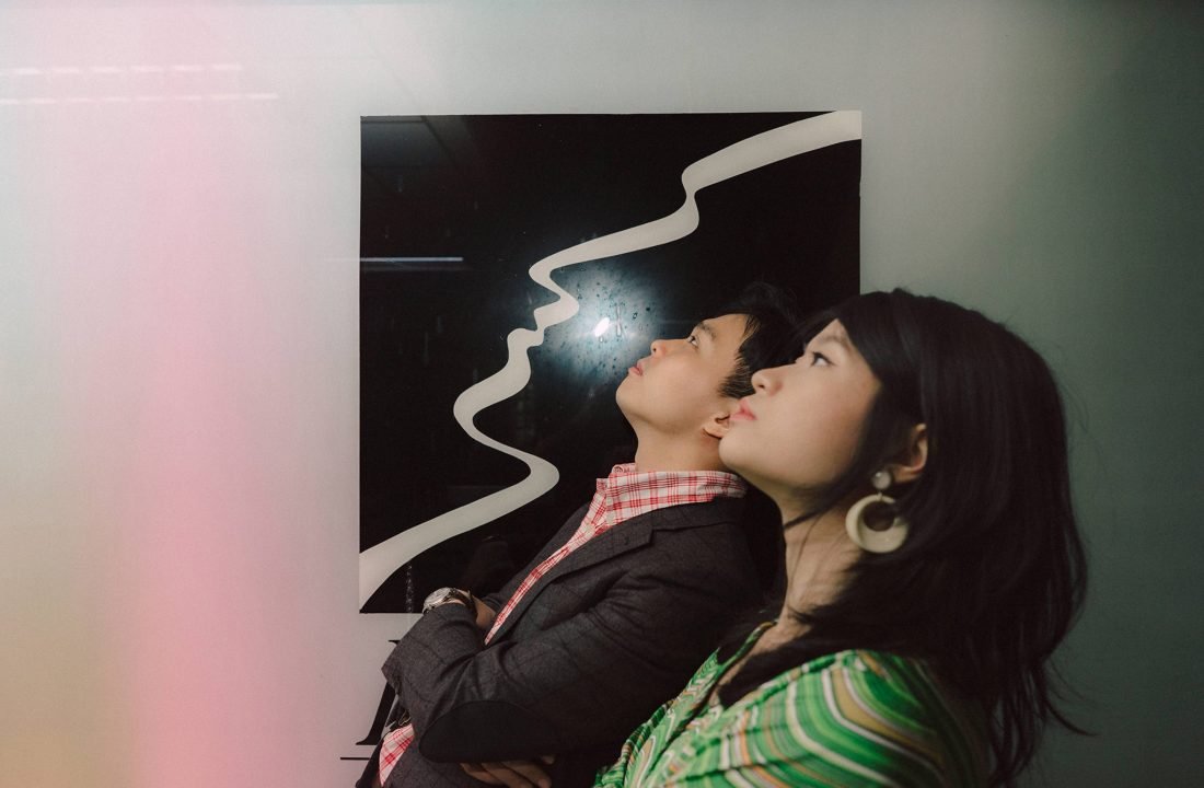 Olivia and Ryan in retro outfits, inspired by city pop prewedding photography in Singapore.
