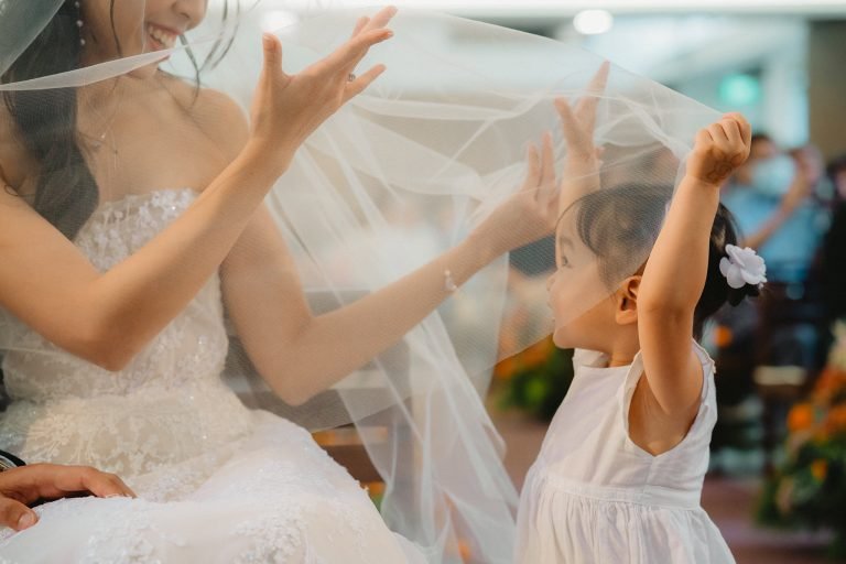 flower girl stealing a moment with the bride at lutheran church in queenstown by singapore wedding photographer