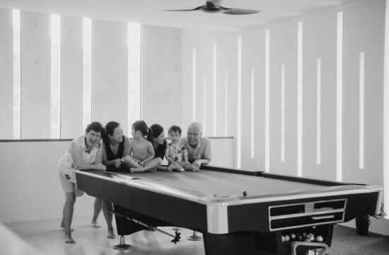Family having a moment on pool table during photography session with Singapore family photographer