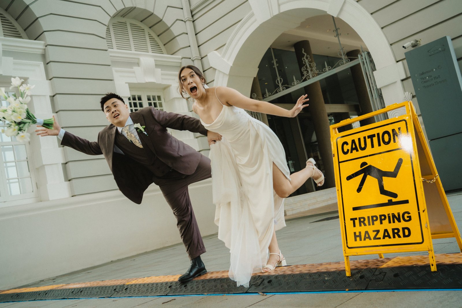Wedding couple playfully posing near a 