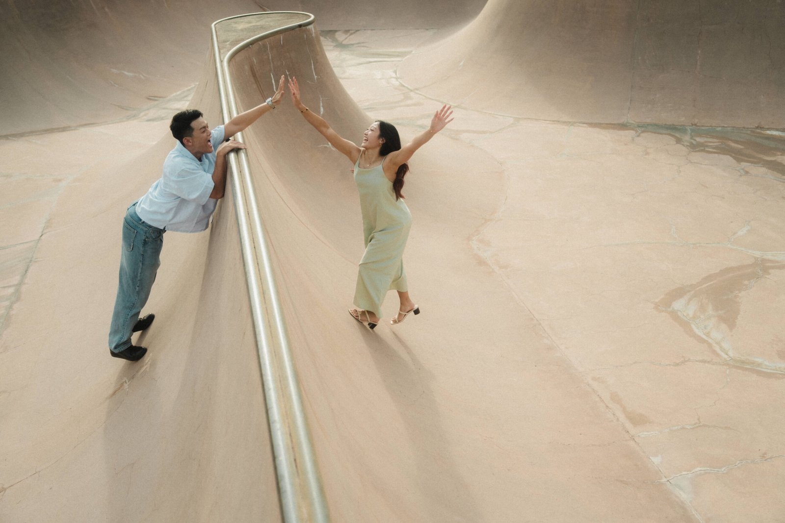 Singapore Wedding Photographer capturing a couple high fiving one another at East Coast Park