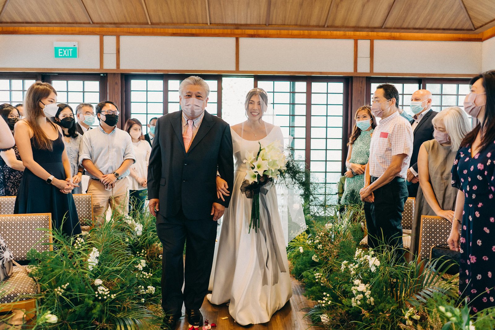 Bride and father walk down aisle at Keyaki Garden Pavilion Wedding Singapore, surrounded by lush greenery.