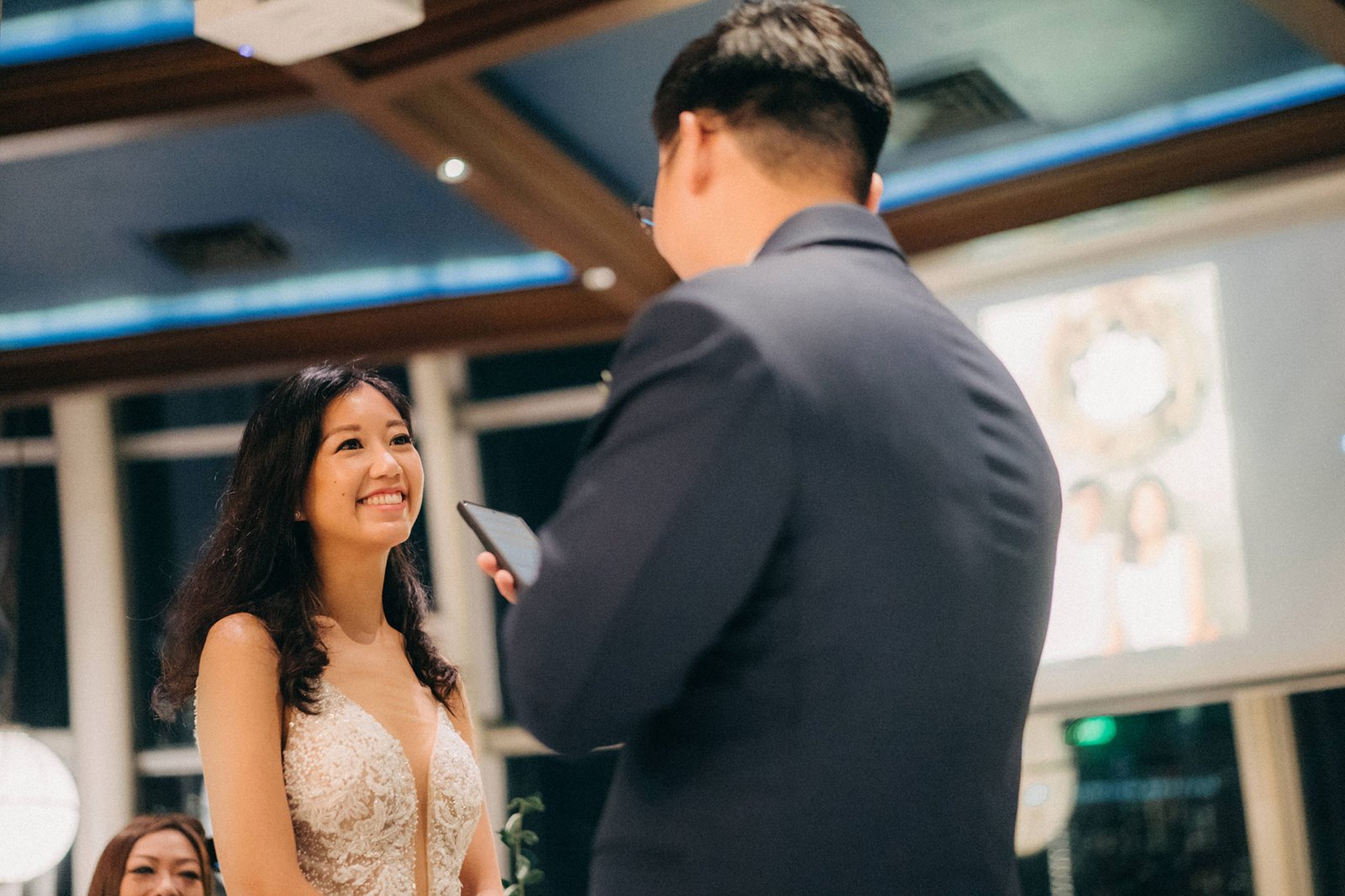 Bride Sophie smiles joyfully at groom LK during their Monti at 1-Pavilion wedding ceremony in Singapore, captured by photography.