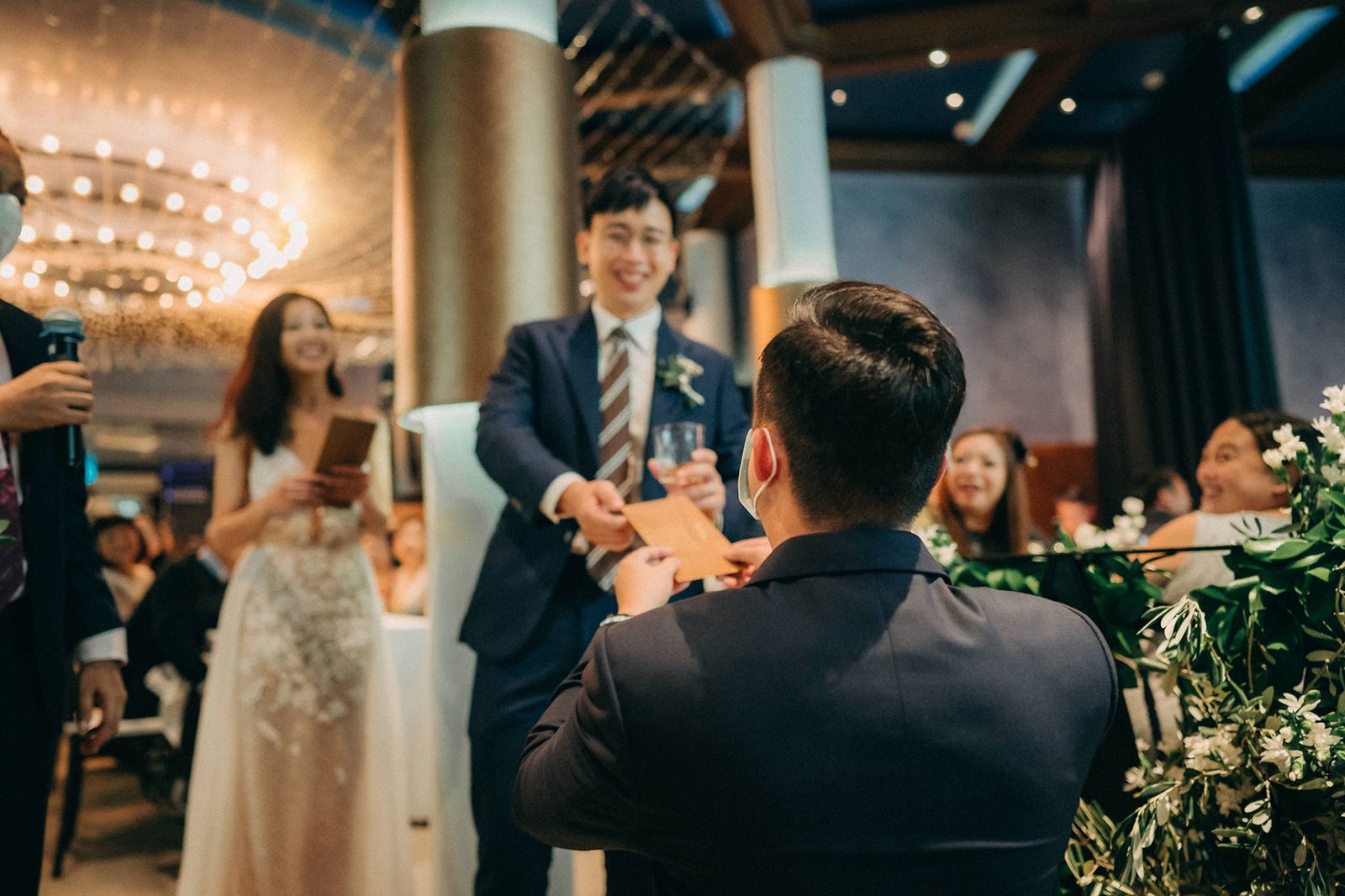 Groom presents an ang pow to the bride during a Monti at 1-Pavilion wedding in Singapore, captured by wedding photography.