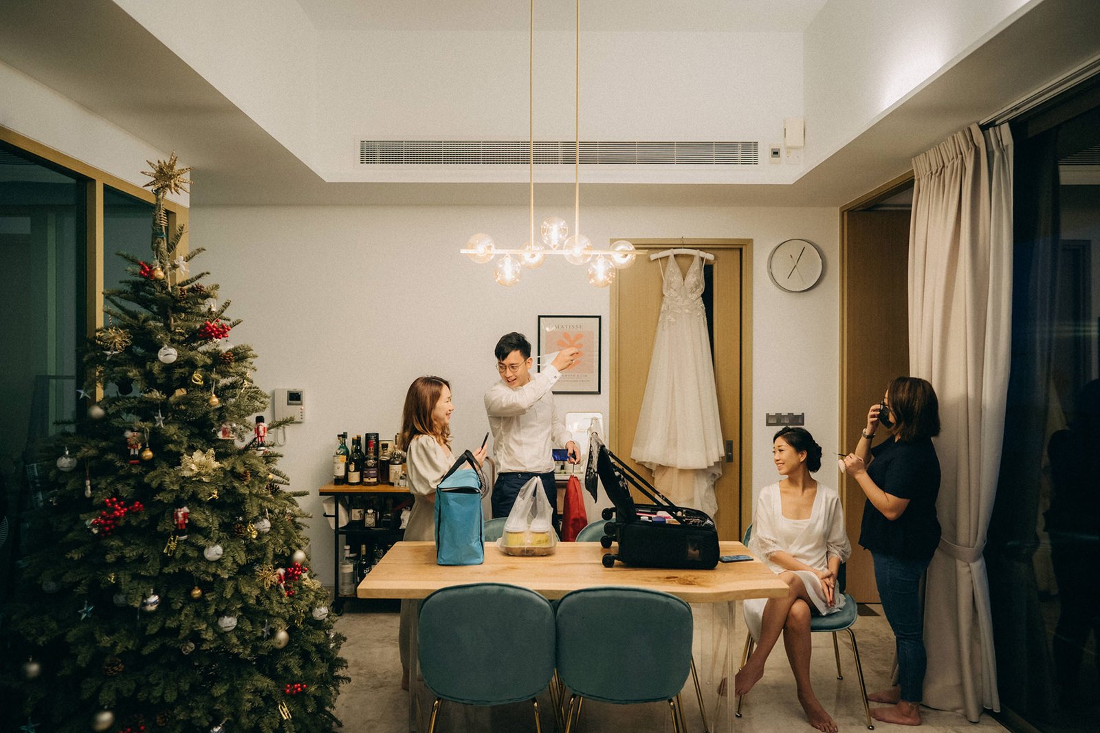 Bride and bridesmaids prepare for a wedding at Monti at 1-Pavilion, Singapore, with a Christmas tree and wedding dress visible. Photography by Monti Circles.