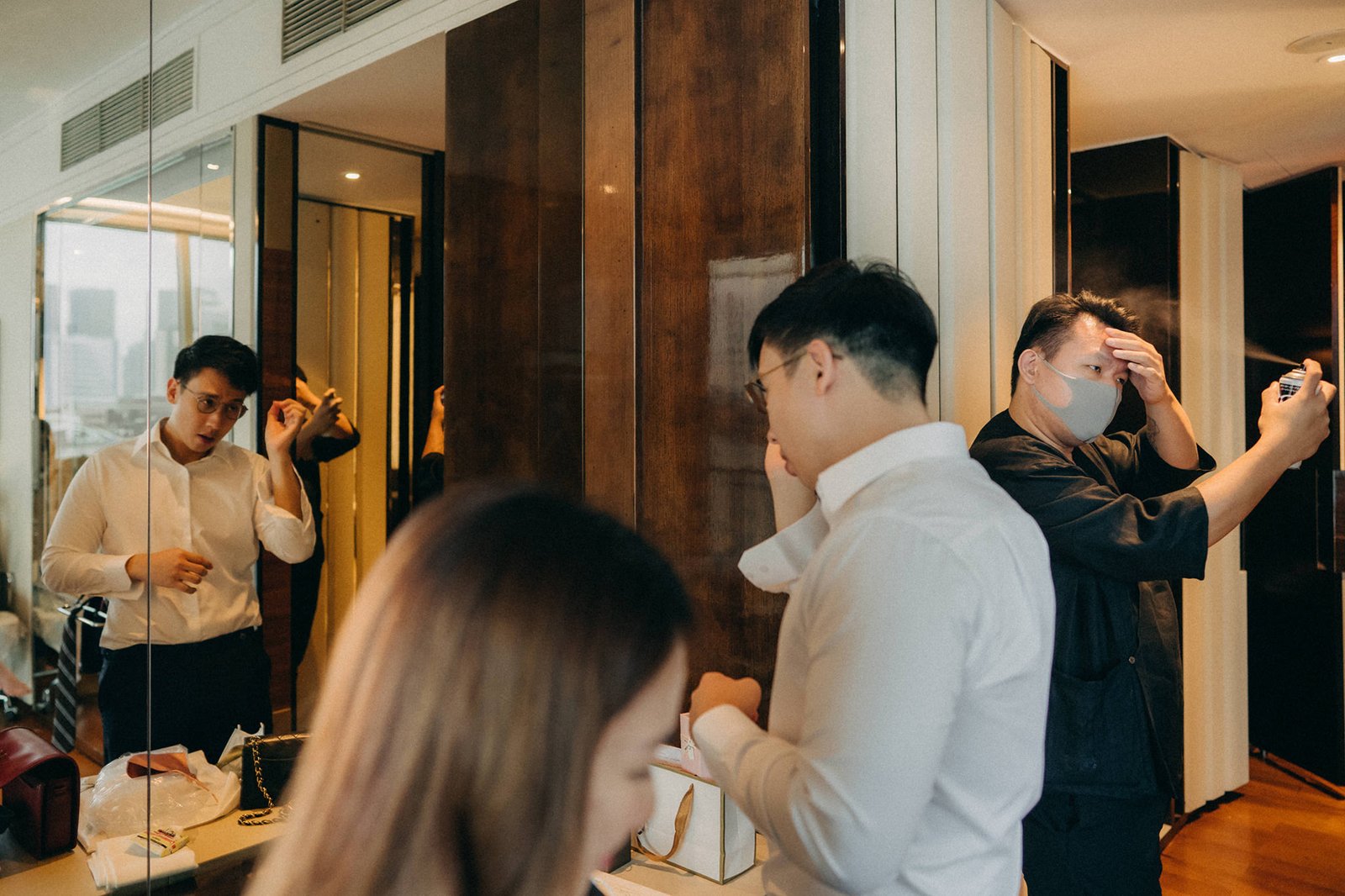 Groom getting ready for his Monti at 1-Pavilion wedding in Singapore, with groomsmen helping him. Photography captures the moments before the ceremony.