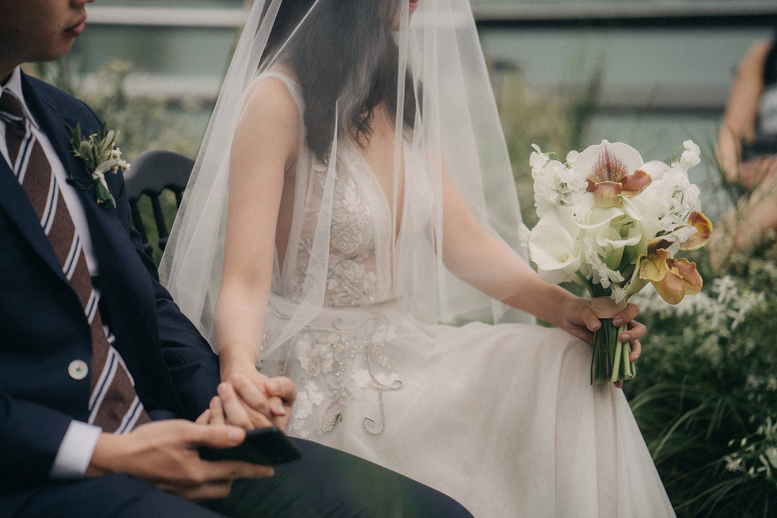 A bride in a white wedding dress and veil holds a bouquet next to her groom at a Monti at 1-Pavilion wedding in Singapore, captured by photography.
