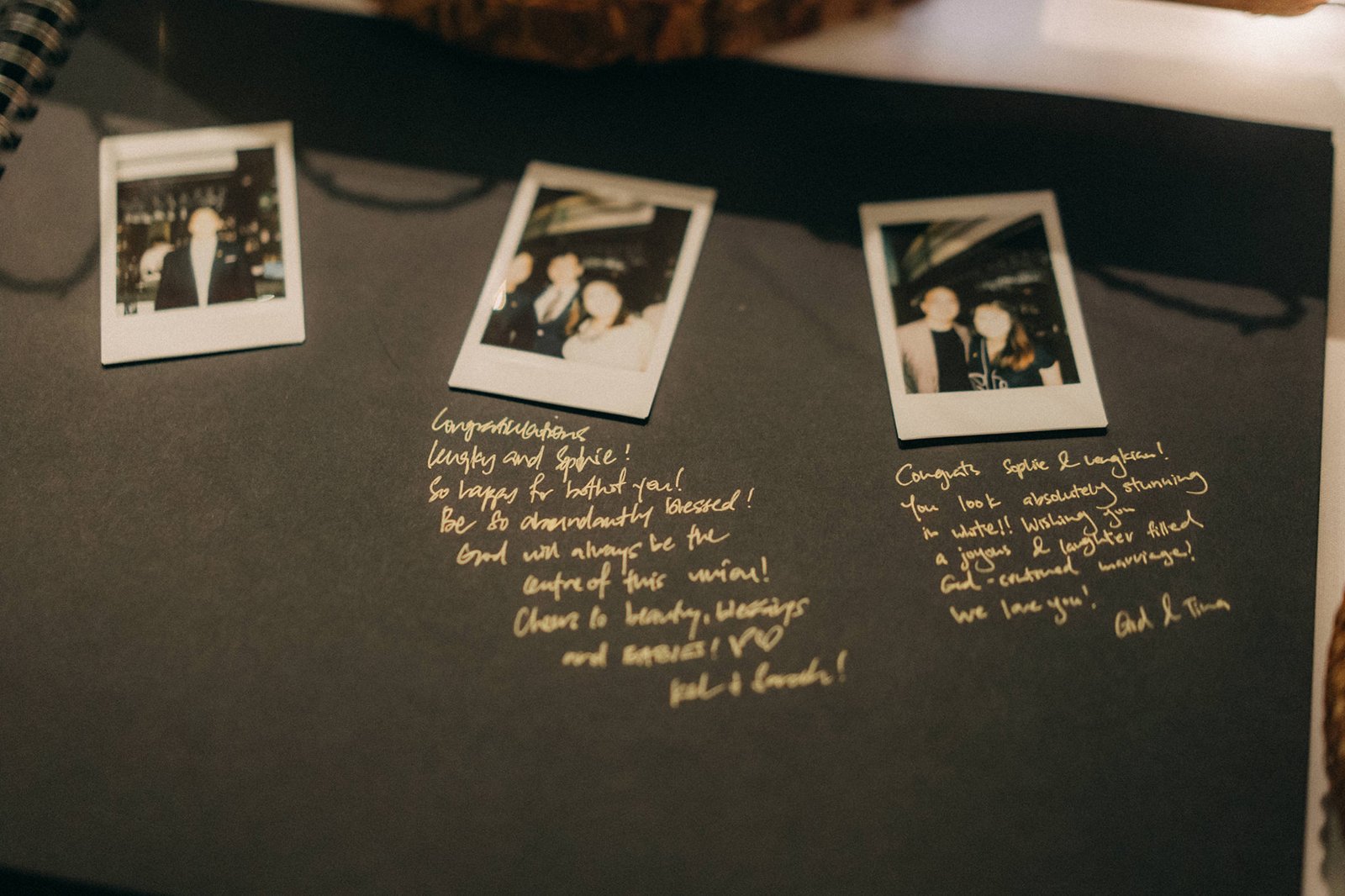 A wedding guest book with three instant photos of a couple, alongside handwritten golden messages. The photos and messages are on a black page, possibly at a Monti Circles wedding.
