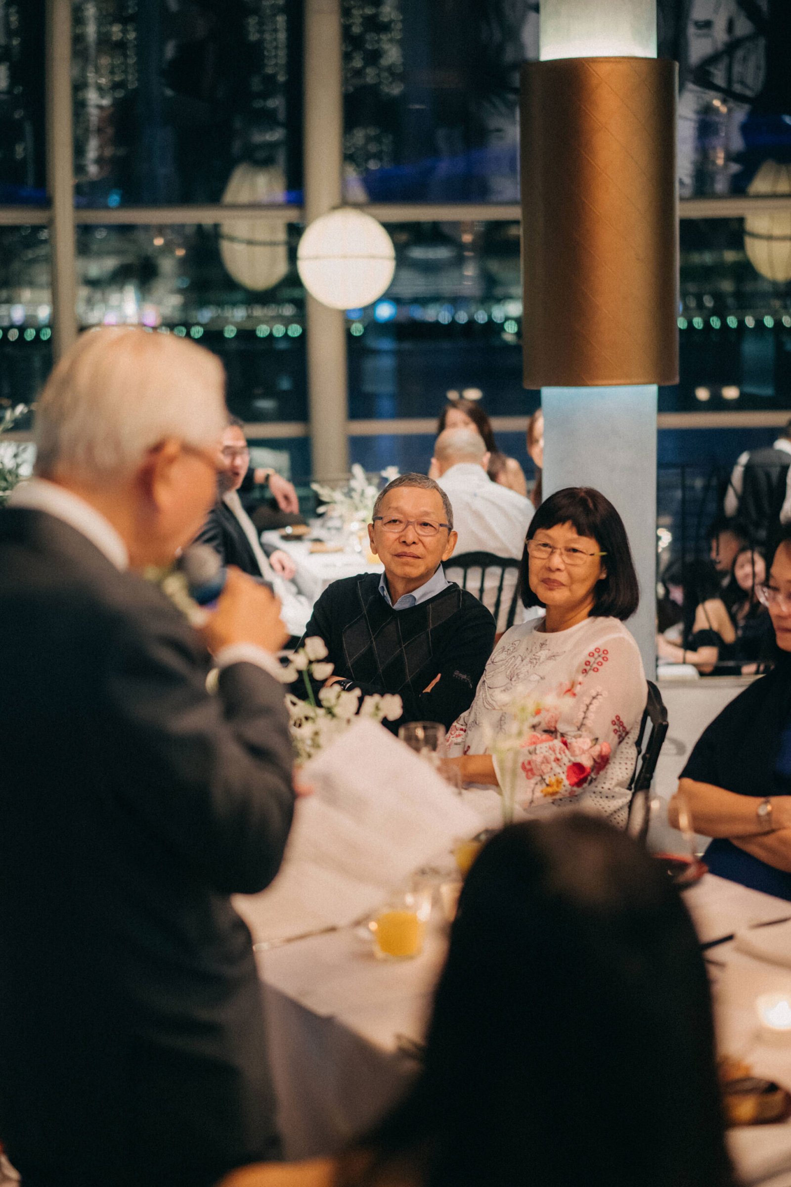 Wedding reception at 1-Pavilion, Singapore with guests seated around tables, including groom's parents
