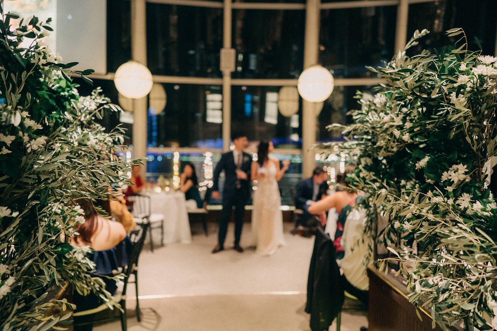 A romantic wedding reception at Monti at 1-Pavilion, Singapore, with lush greenery, soft lighting, and a couple embracing. This Monti at 1-Pavilion wedding photography captures the elegant ambiance.