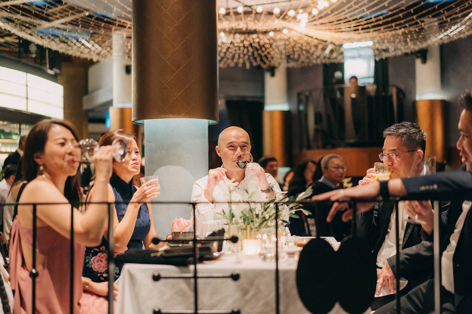 Guests enjoy a wedding reception at Monti at 1-Pavilion, Singapore, with elegant decor and ambient lighting.