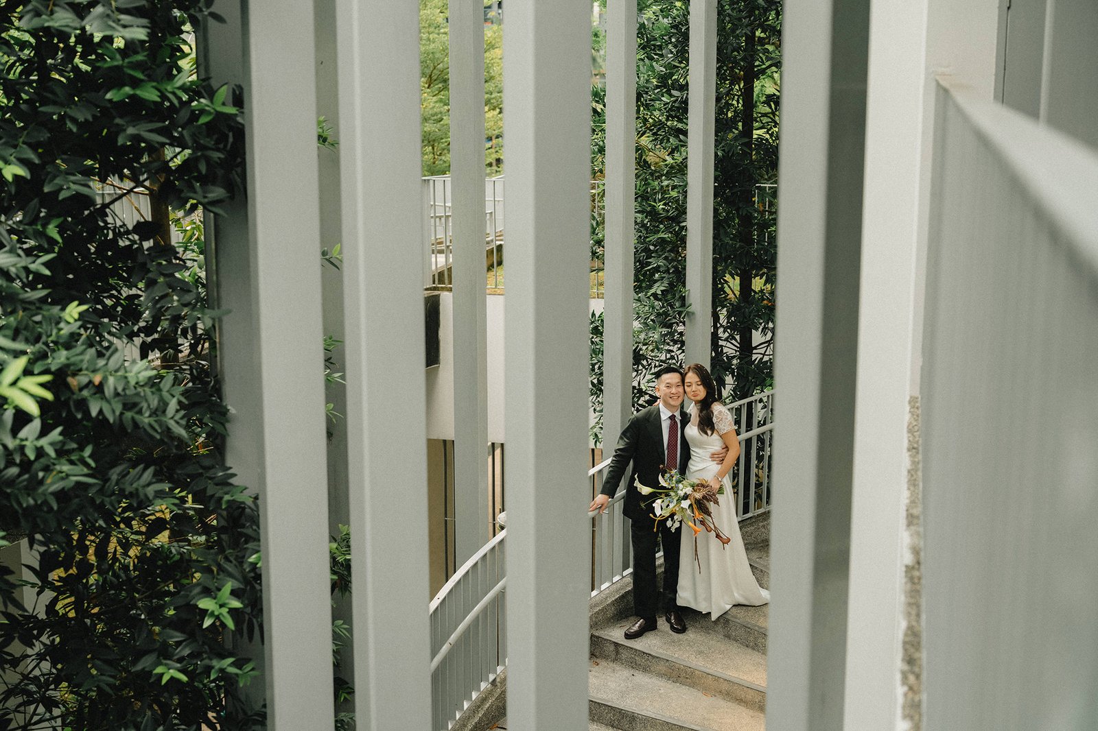 Jared and Xinyu's Atlas Bar Singapore wedding: couple on staircase