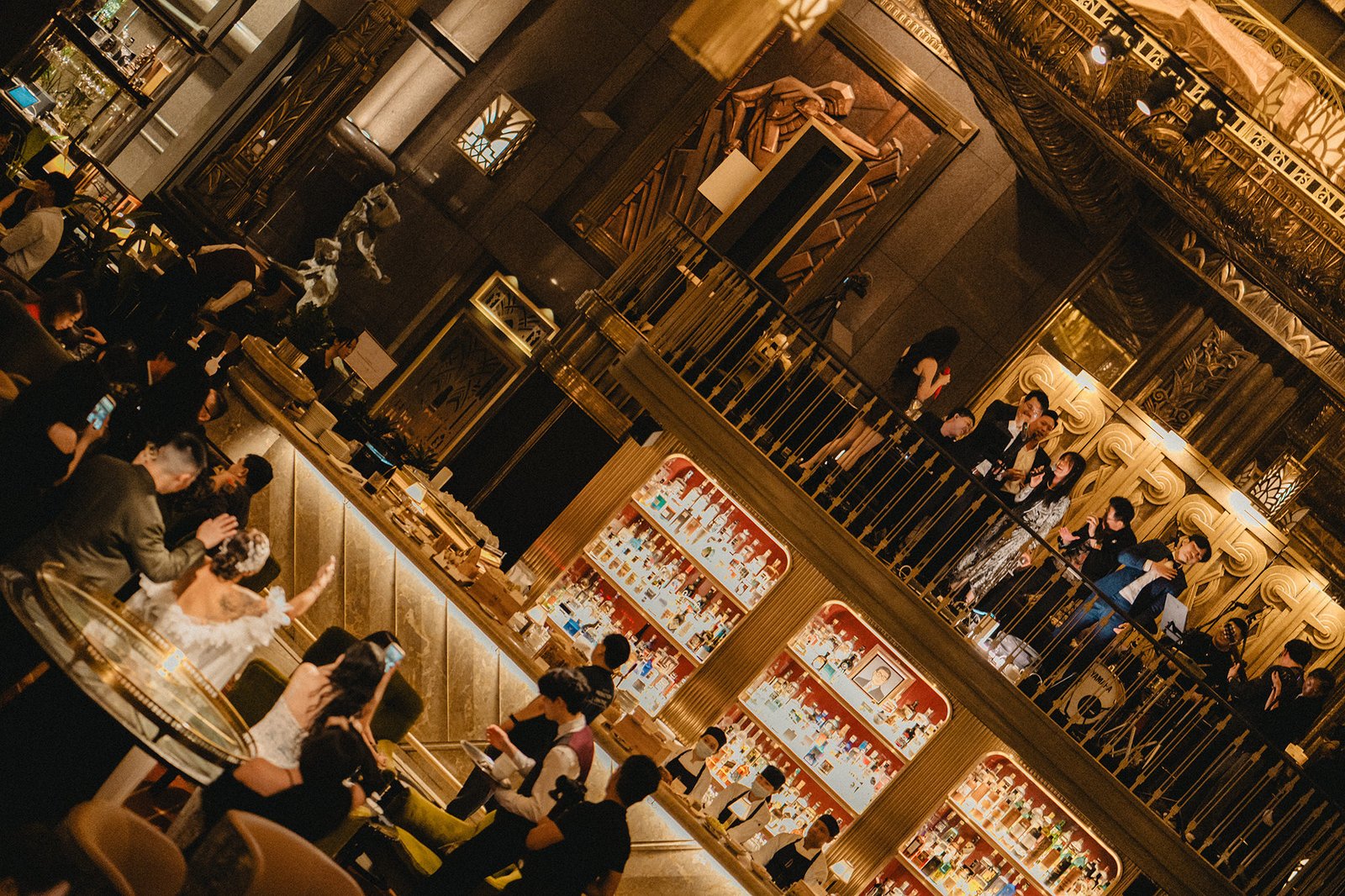 Jared and Xinyu's wedding reception at Atlas Bar Singapore, featuring guests and opulent decor.