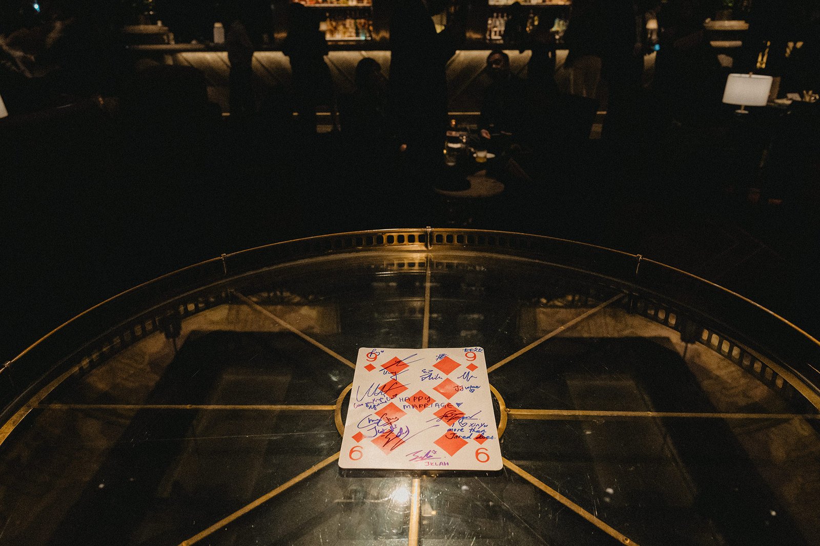 Signed playing card on table at Atlas bar Singapore wedding reception