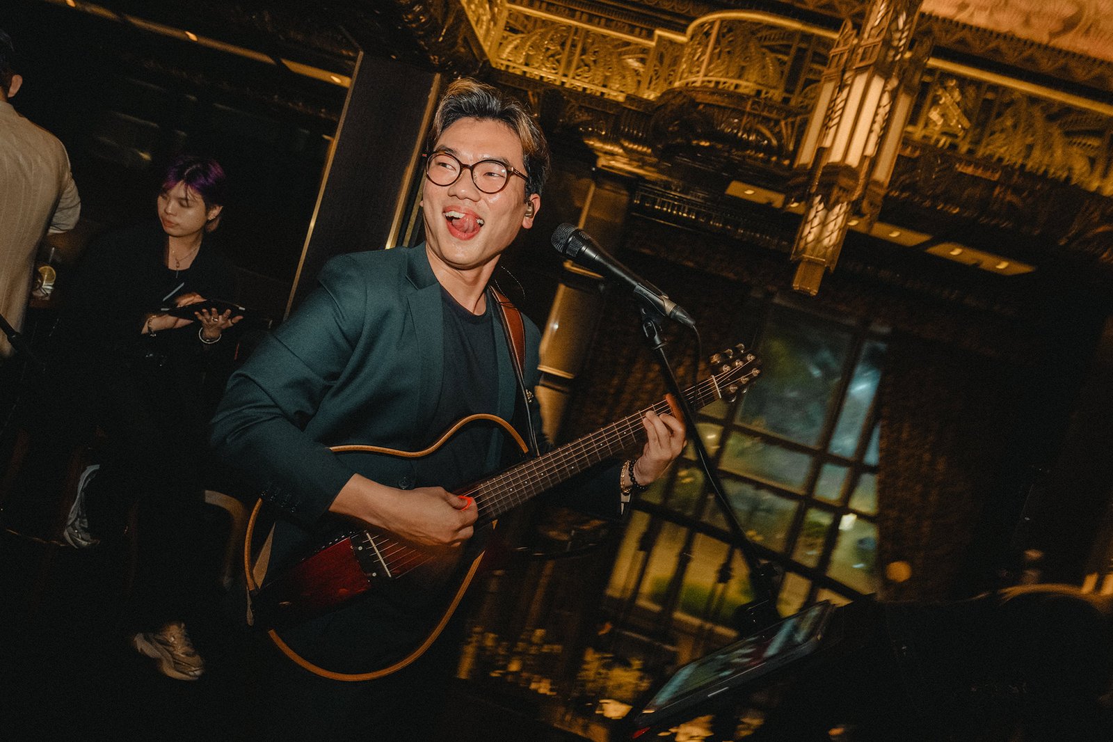 Groom Jared plays guitar at Atlas Bar Singapore wedding celebration