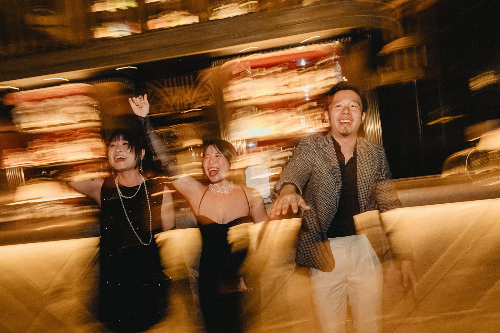 Jared and Xinyu celebrate at Atlas Bar Singapore wedding, joyful friends dancing