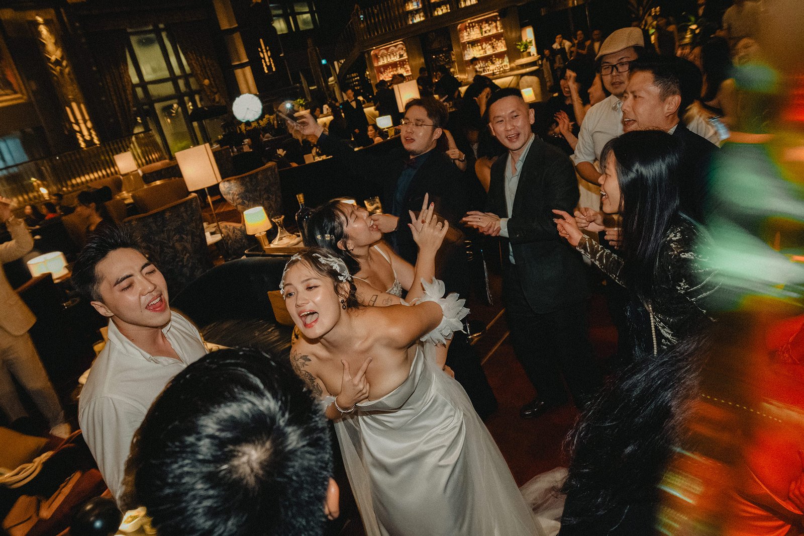 Jared and Xinyu's vibrant Atlas Bar Singapore wedding reception with guests dancing.