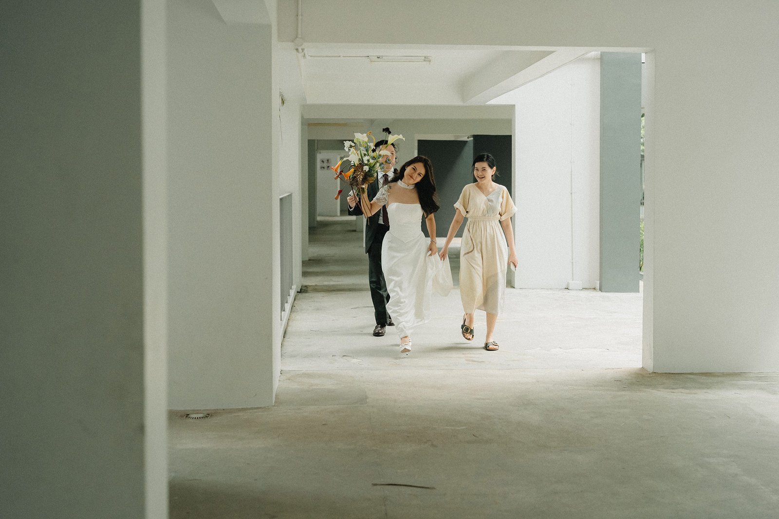 Bride and wedding party walk down hallway at Atlas Bar Singapore wedding