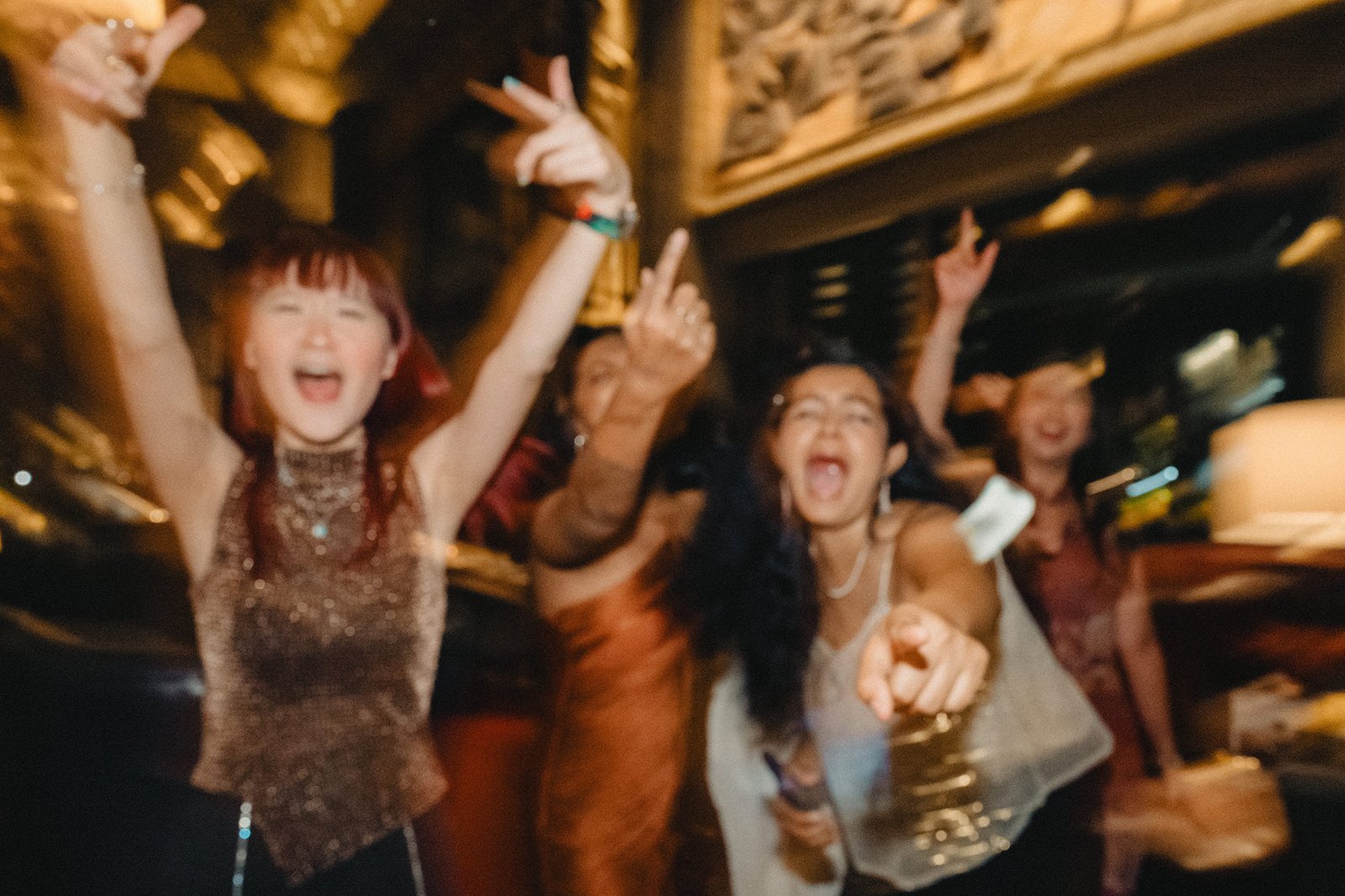 Jared and Xinyu's wedding celebration at Atlas Bar Singapore with friends dancing.