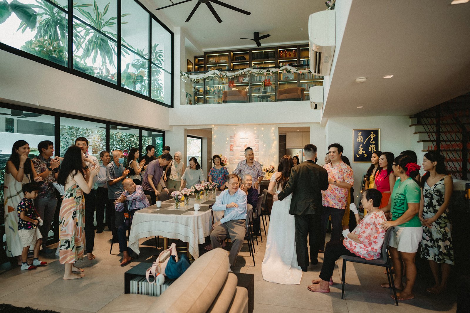 Jared and Xinyu's wedding at Atlas Bar, Singapore, with guests gathered in a modern home.