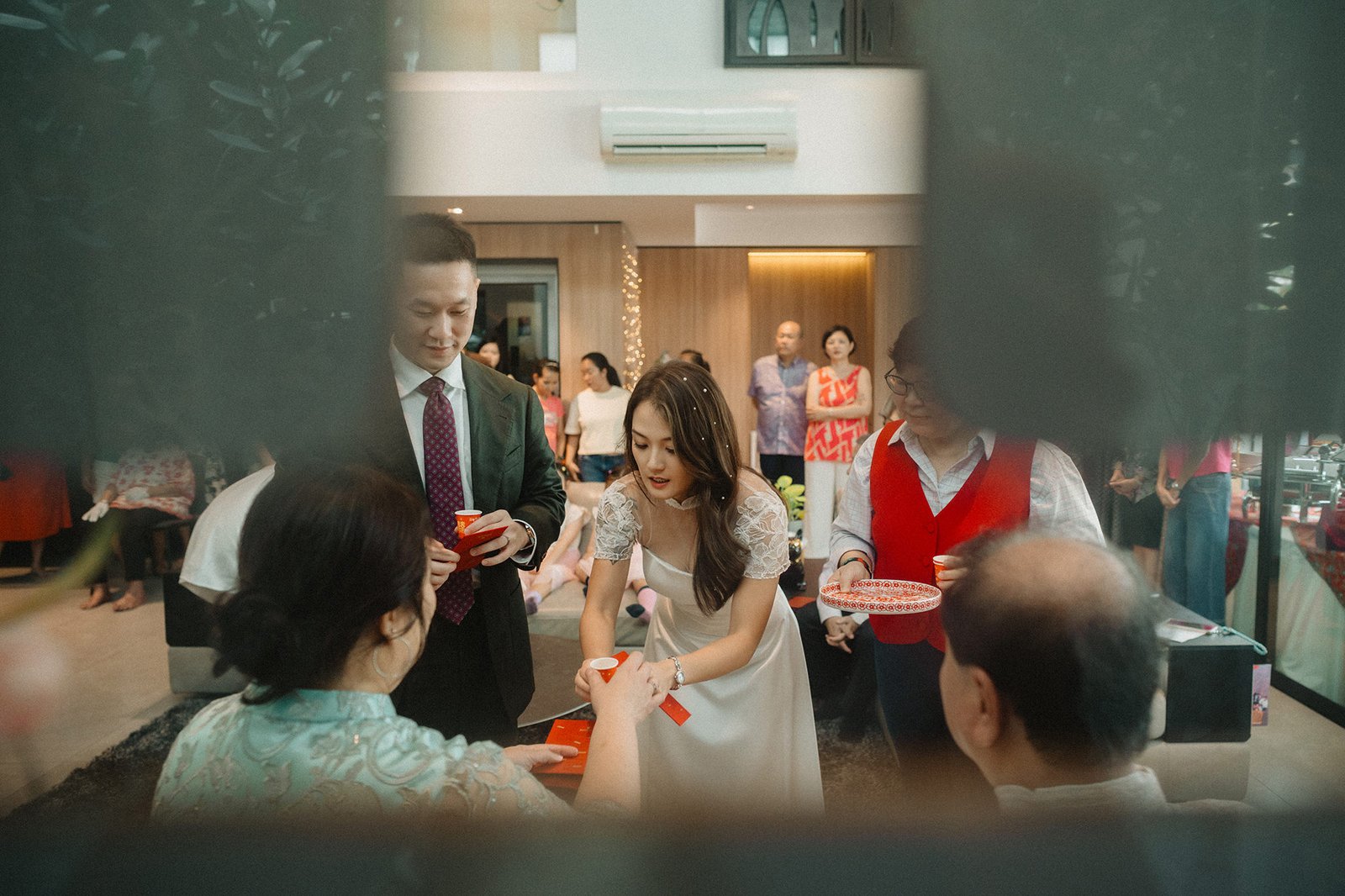 Bride and groom exchange red envelopes at Atlas Bar Singapore wedding