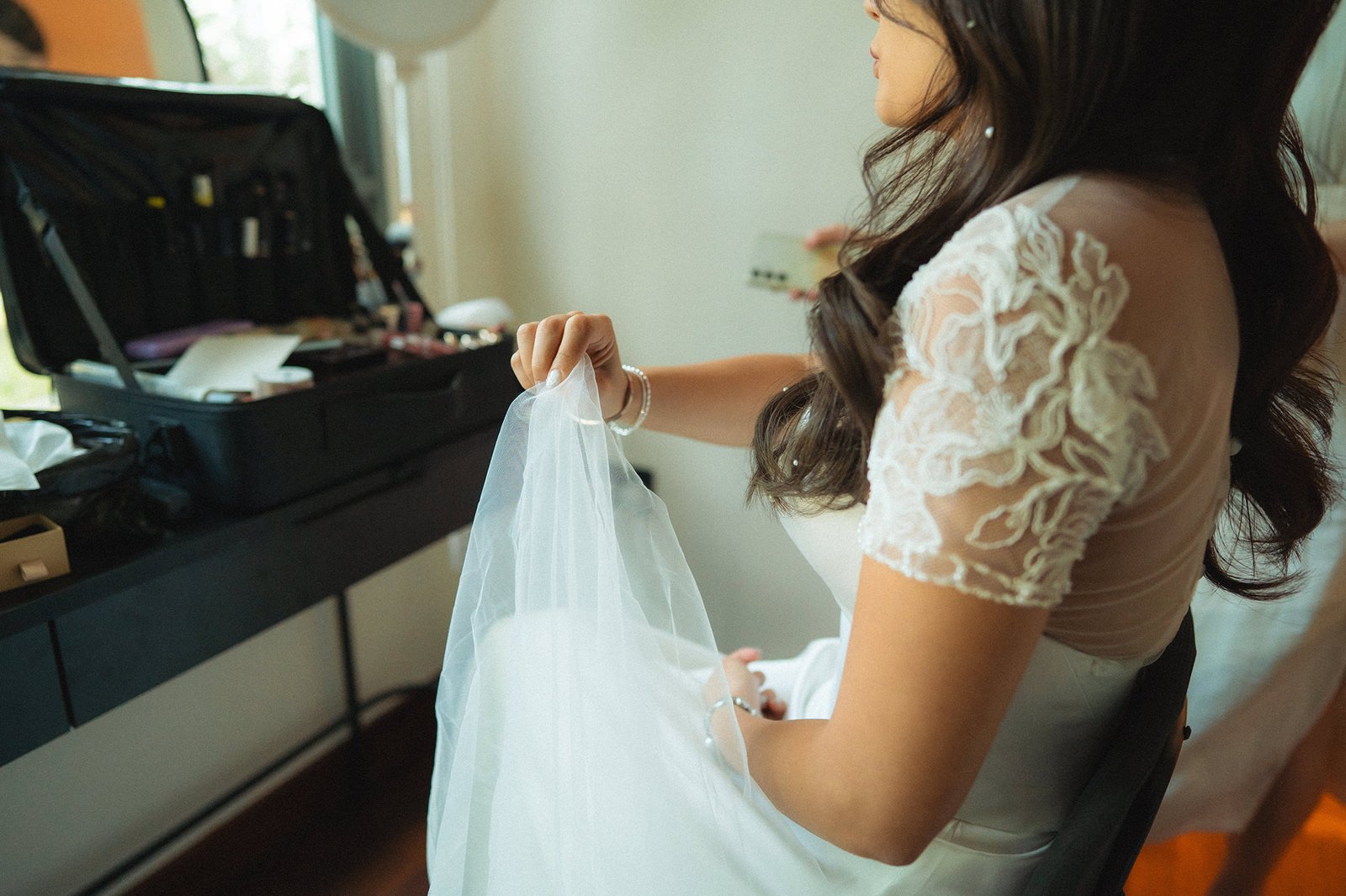 Bride in white dress holding veil at Atlas Bar Singapore wedding