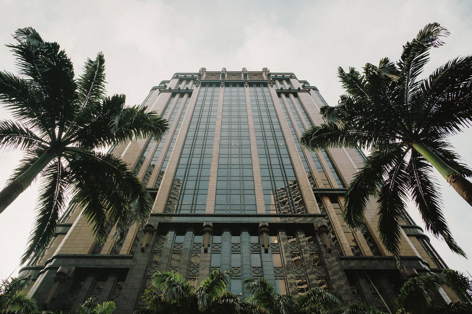Jared + Xinyu wedding at Atlas Bar Singapore: Grand building facade with palm trees.