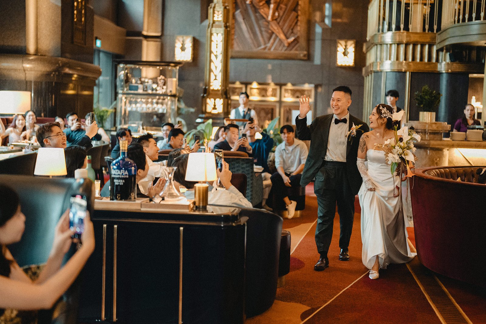 Jared and Xinyu's Atlas Bar Singapore wedding: couple waves to guests