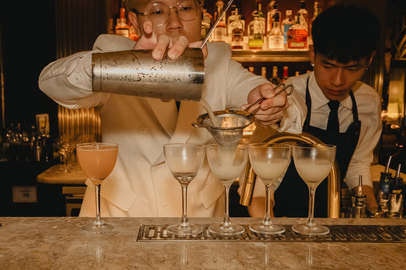 Bartenders at Atlas Bar Singapore prepare cocktails for a wedding celebration.