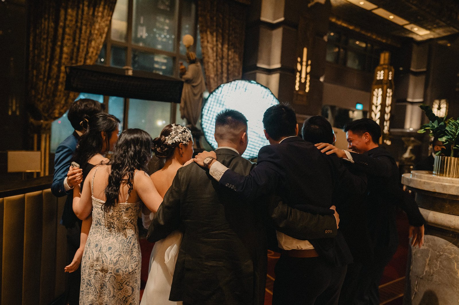 Jared and Xinyu's wedding at Atlas Bar Singapore, guests hug the couple.