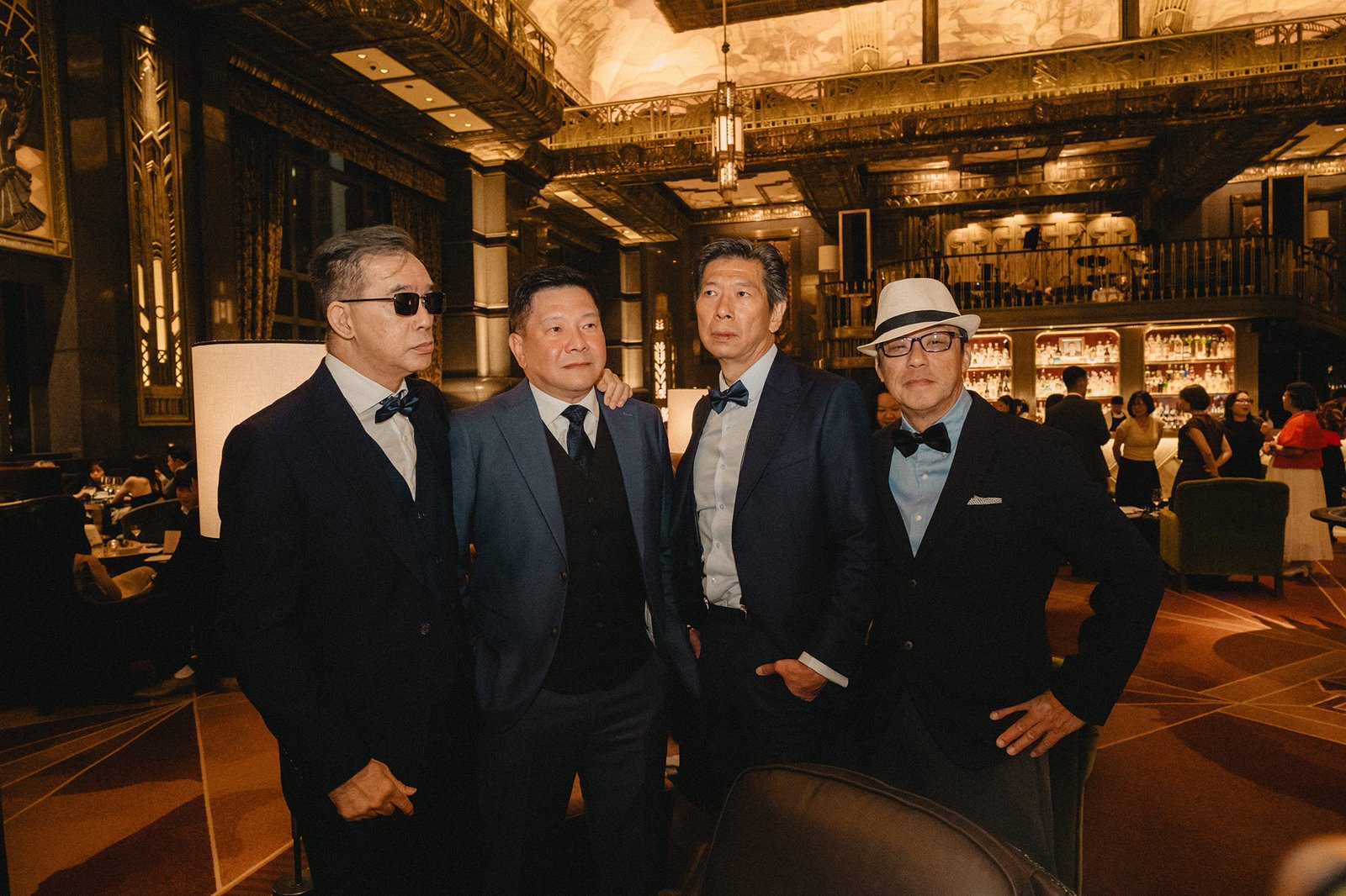 Four men in suits pose at Atlas Bar Singapore wedding.