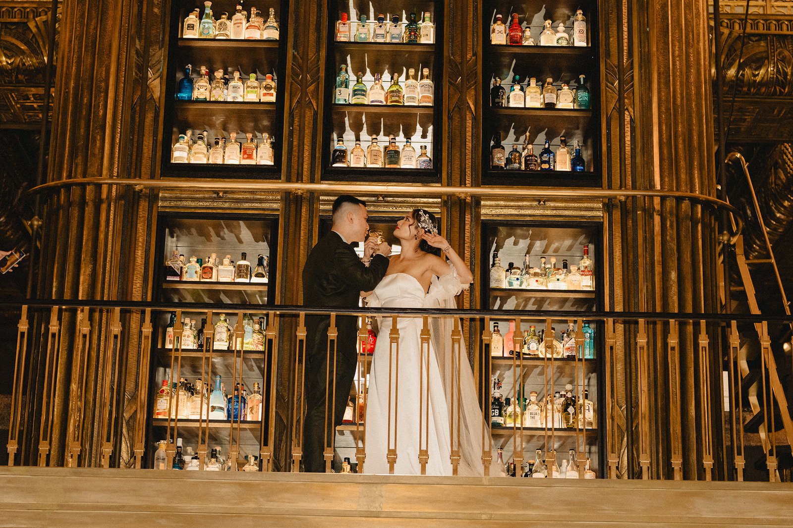 Jared and Xinyu's wedding at Atlas Bar Singapore, with shelves of liquor bottles.