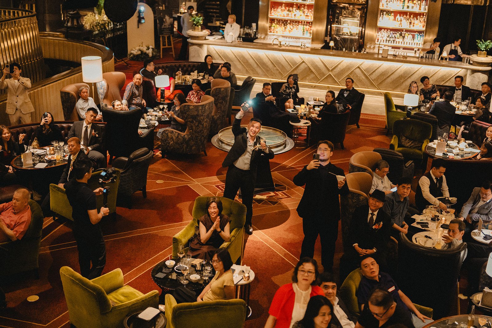 Jared and Xinyu's wedding reception at Atlas Bar Singapore, guests mingling in opulent art deco setting.