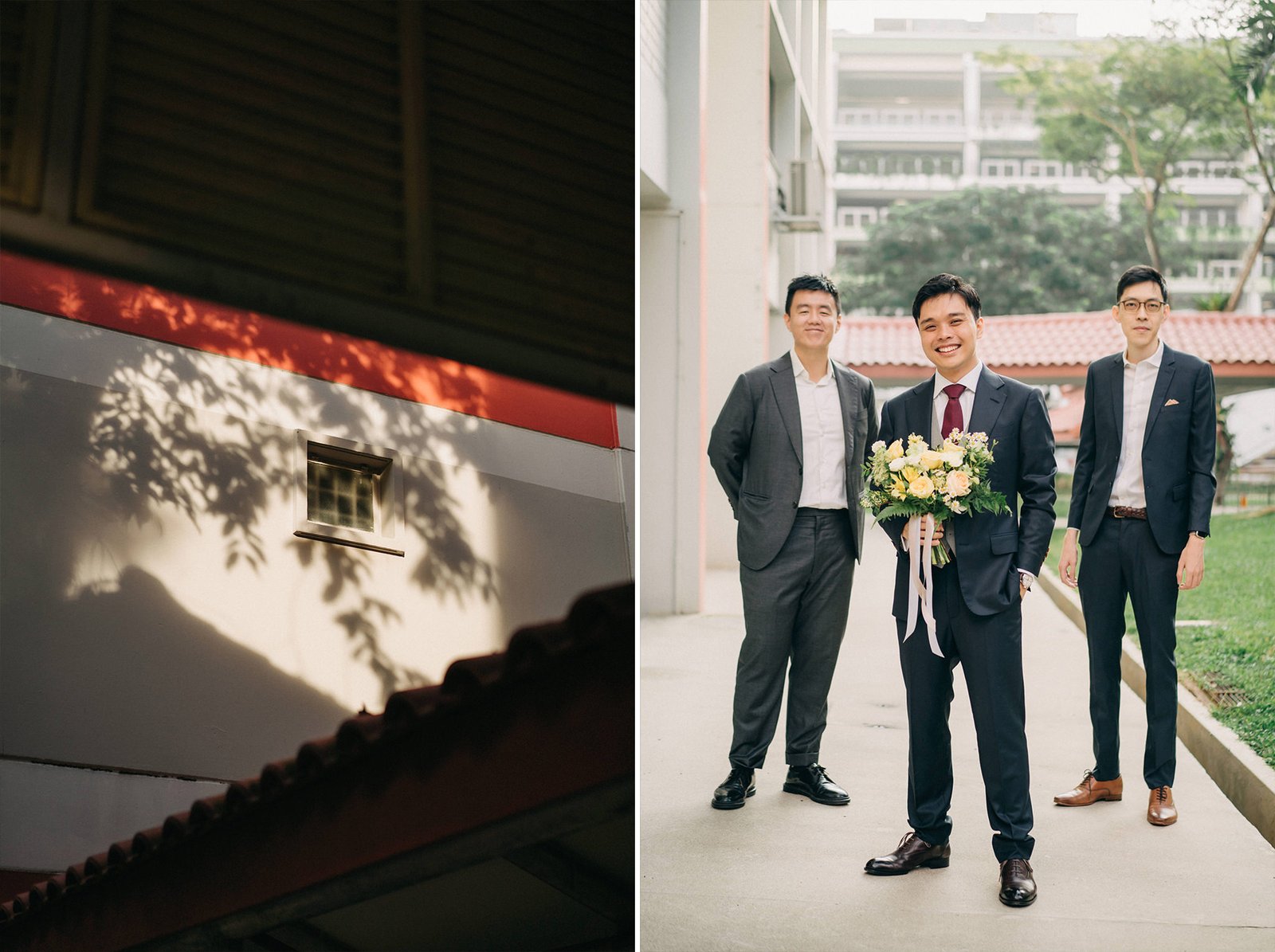 Three men in formal suits pose for a wedding photo outside a modern building, one holding a bouquet.