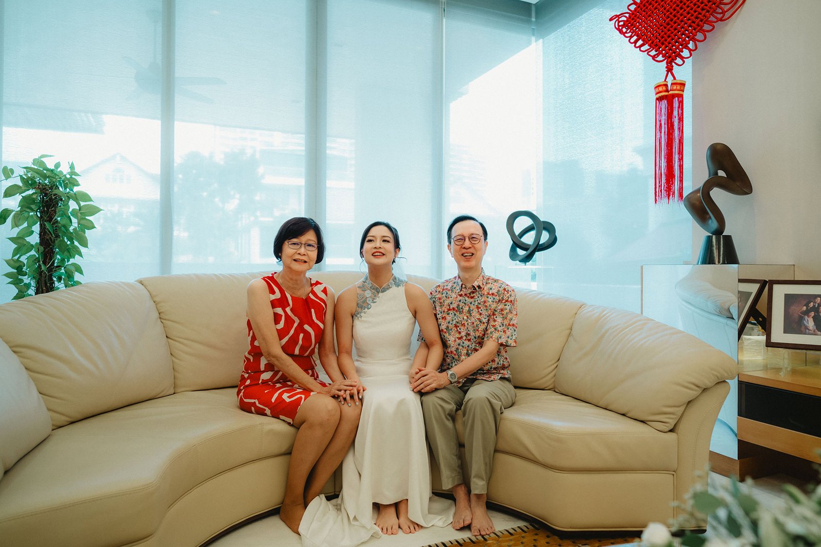 Han and Ming's family at Capella Singapore wedding, smiling on a couch.