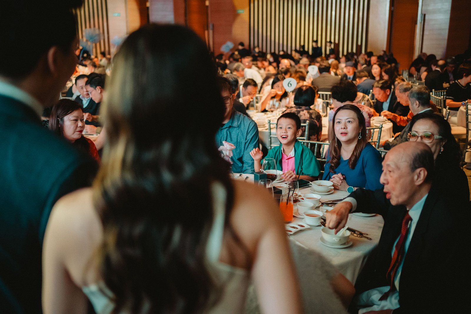 Capella Singapore wedding reception: guests seated at tables, a boy smiles