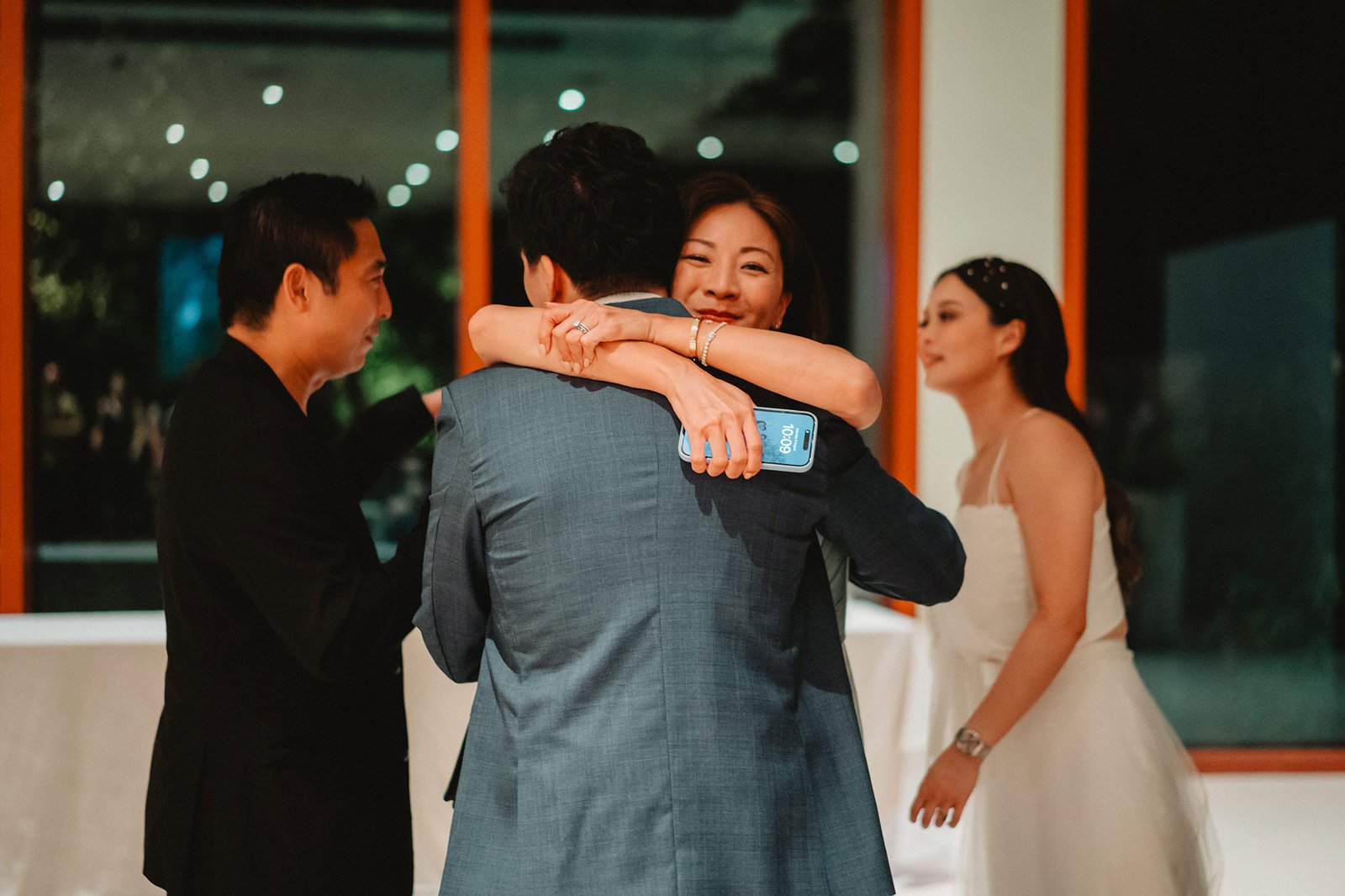 Han and Ming embrace at their Capella Singapore wedding, with guests watching.