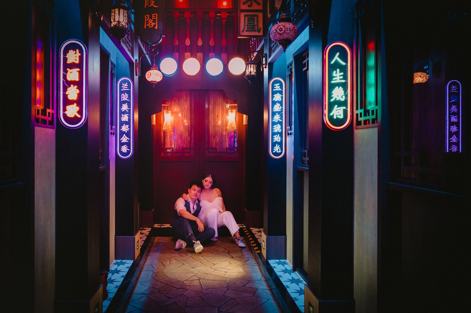 Capella Singapore wedding: Han and Ming pose in a neon-lit alley.