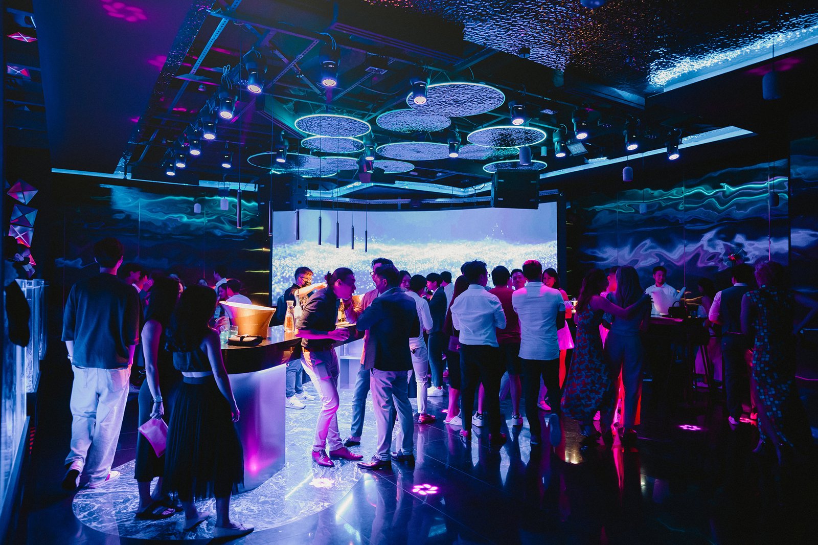 Capella Singapore wedding party with guests dancing under purple lights