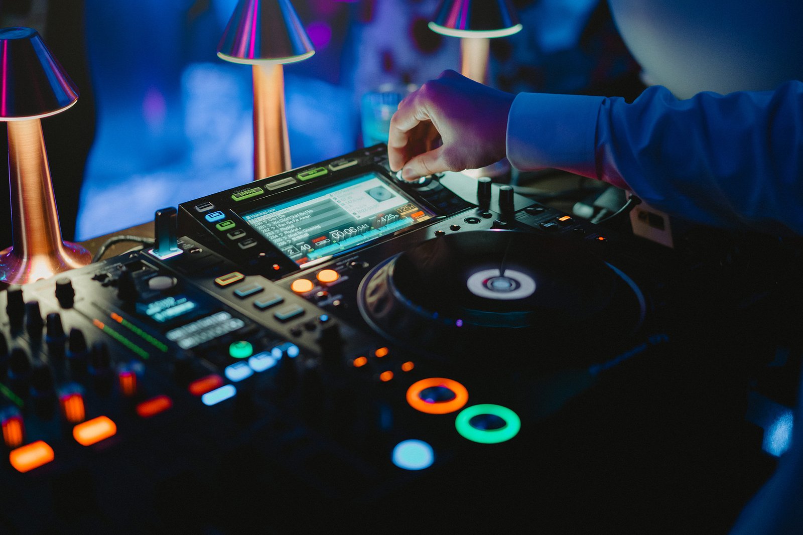 DJ at Capella Singapore wedding reception, mixing music on equipment