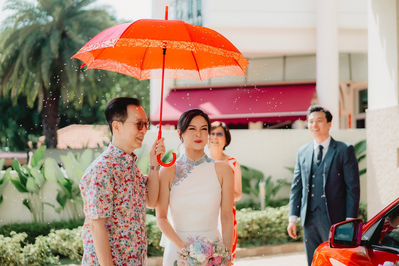 Capella Singapore wedding: Couple under red umbrella during Han + Ming's celebration