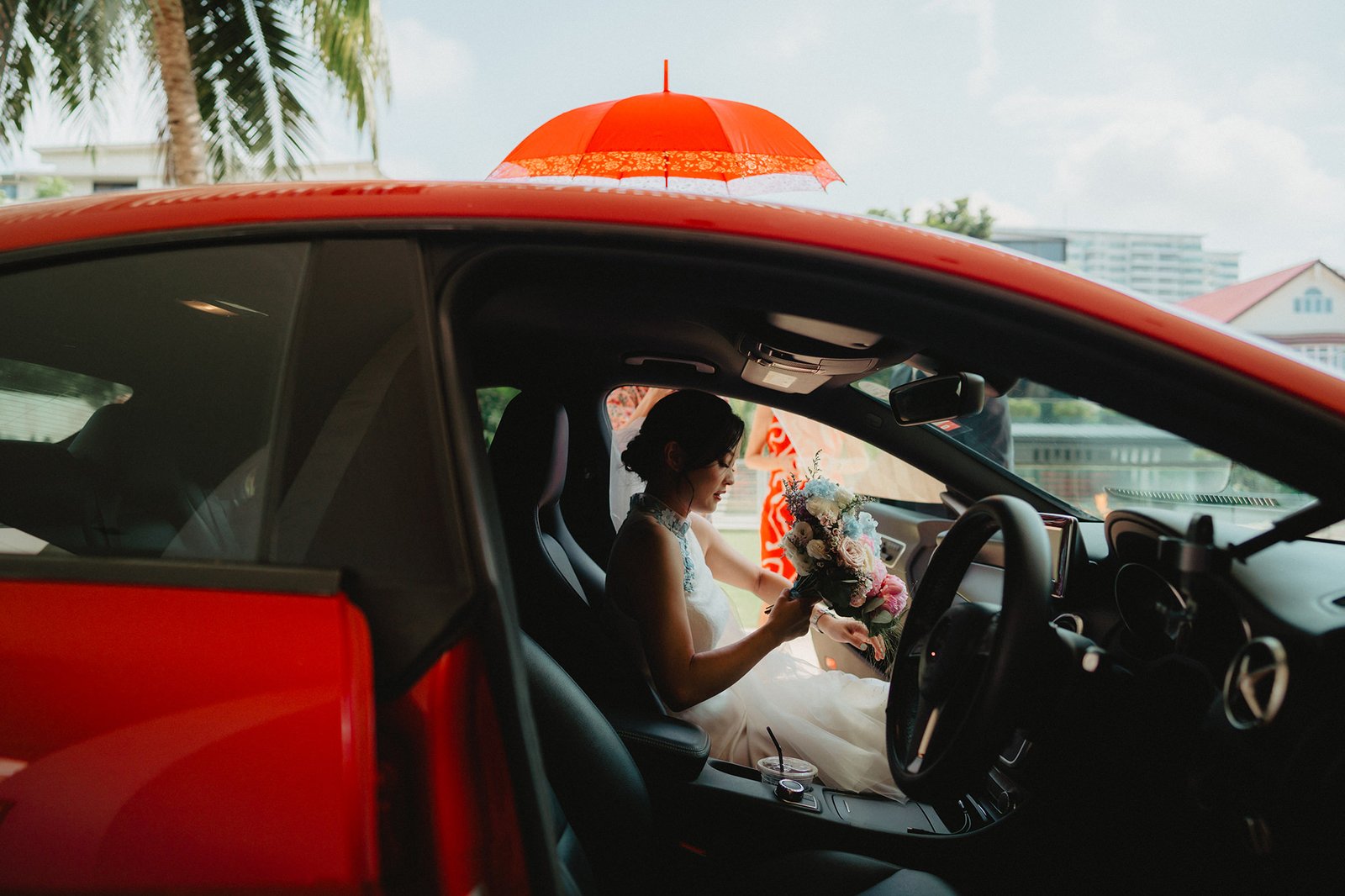 Bride with bouquet in red car at Capella Singapore wedding